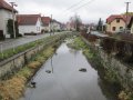 Tok Bratřejovky podél ulice Poštovní se zpevněnými břehy